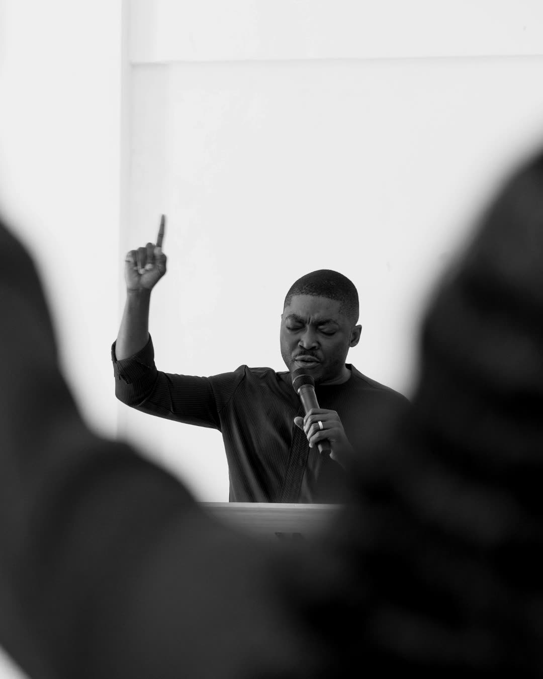 A man praying with one hand raised during a Prayer Room gathering