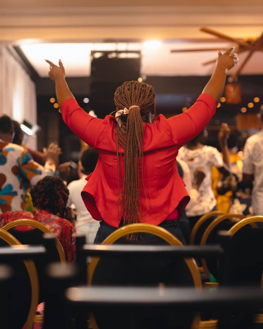 A worshipper with hands raised during a Truth Unveiled Ministries gathering